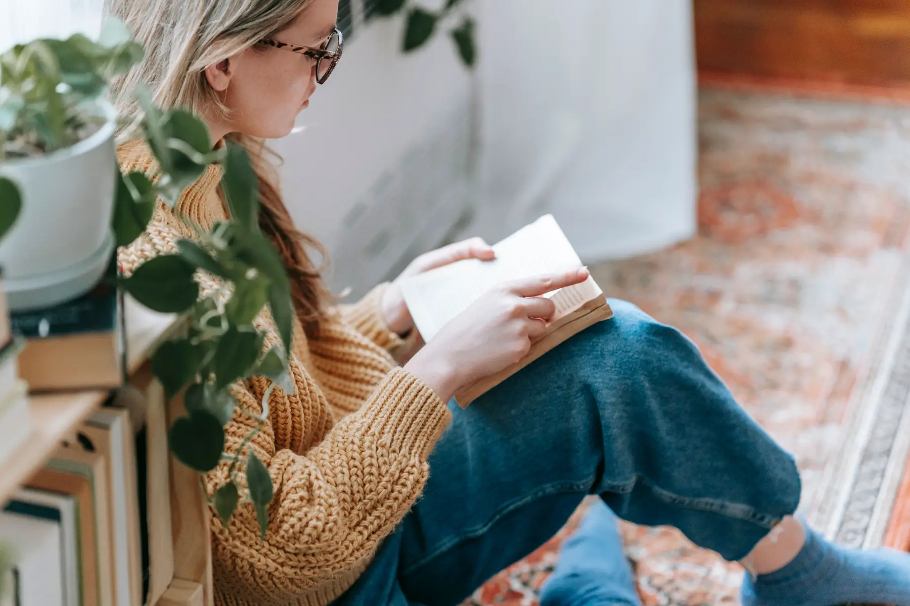 Reader sitting by a window with an open book